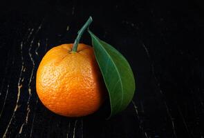 Two ripe juicy tangerines on a black background. photo