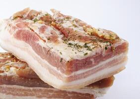 Appetizing salty lard with layers of meat with garlic and herbs. Two pieces of salted lard on a white background. photo