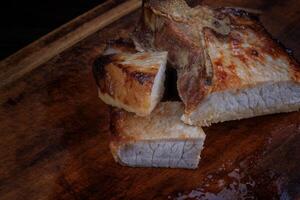 Roasted pork entrecote cut into pieces on a wooden cutting board. Grilled pork entrecote. Pork steak. photo