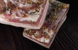 Appetizing salty lard with layers of meat. Salted lard with garlic and herbs. photo