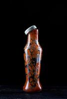 Tomato sauce . Empty ketchup bottle. Glass bottle with remaining ketchup inside on a black background. photo