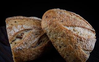 A loaf of bread cut in half on a wooden board. Art bread. photo