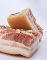 Appetizing salty lard with layers of meat with garlic and herbs. Two pieces of salted lard on a white background. photo