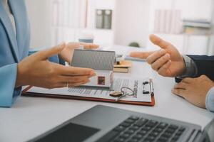 El agente de bienes raíces habló sobre los términos del contrato de compra de vivienda y le pidió al cliente que firmara los documentos para hacer el contrato legalmente, concepto de venta de vivienda y seguro de vivienda. foto