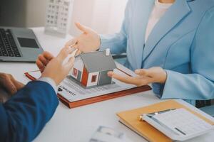Real estate agent talked about the terms of the home purchase agreement and asked the customer to sign the documents to make the contract legally, Home sales and home insurance concept. photo