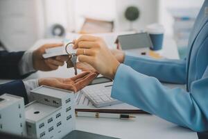 El agente de bienes raíces habló sobre los términos del contrato de compra de vivienda y le pidió al cliente que firmara los documentos para hacer el contrato legalmente, concepto de venta de vivienda y seguro de vivienda. foto