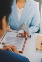 Real estate agent talked about the terms of the home purchase agreement and asked the customer to sign the documents to make the contract legally, Home sales and home insurance concept. photo