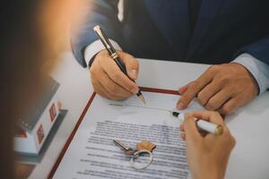 Real estate agent talked about the terms of the home purchase agreement and asked the customer to sign the documents to make the contract legally, Home sales and home insurance concept. photo