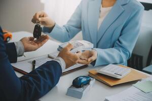 Insurance officers hand over the car keys after the tenant. have signed an auto insurance document or a lease or agreement document Buying or selling a new or used car with a car photo