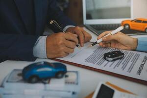 Insurance officers hand over the car keys after the tenant. have signed an auto insurance document or a lease or agreement document Buying or selling a new or used car with a car photo