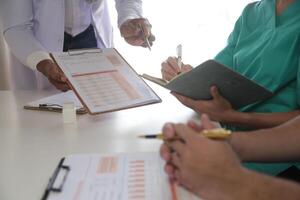 médico equipo reunión alrededor mesa en moderno hospital foto