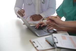 médico equipo reunión alrededor mesa en moderno hospital foto