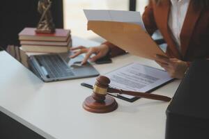 americano mujer abogado o mujer de negocios africano trabajando con computadora portátil, buscando, analizando datos, leyendo contrato documentos trabajo con ley libros martillo de justicia consultante abogado concepto. foto