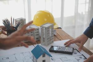 concepto de construcción y estructura de reunión de ingenieros o arquitectos para el proyecto que trabaja con socios y herramientas de ingeniería en la construcción de modelos y planos en el lugar de trabajo, contrato para ambas empresas. foto