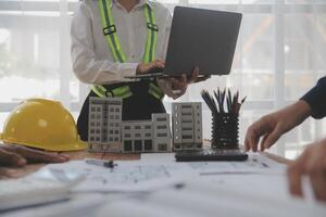 concepto de construcción y estructura de reunión de ingenieros o arquitectos para el proyecto que trabaja con socios y herramientas de ingeniería en la construcción de modelos y planos en el lugar de trabajo, contrato para ambas empresas. foto