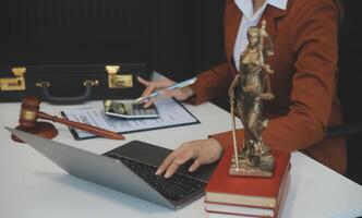 americano mujer abogado o mujer de negocios africano trabajando con computadora portátil, buscando, analizando datos, leyendo contrato documentos trabajo con ley libros martillo de justicia consultante abogado concepto. foto