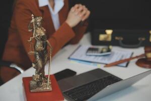 americano mujer abogado o mujer de negocios africano trabajando con computadora portátil, buscando, analizando datos, leyendo contrato documentos trabajo con ley libros martillo de justicia consultante abogado concepto. foto