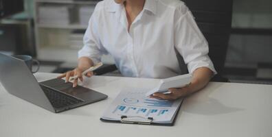 mujer sentado a escritorio y trabajando a computadora manos cerca arriba foto