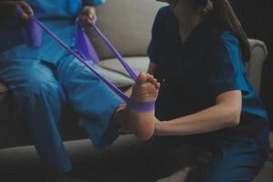 Unrecognizable senior physiotherapist working with a female patient. photo