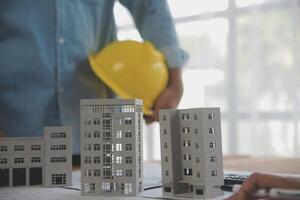 Construction and structure concept of Engineer or architect meeting for project working with partner and engineering tools on model building and blueprint in working site, contract for both companies. photo
