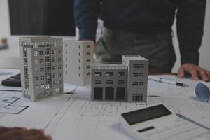 Construction and structure concept of Engineer or architect meeting for project working with partner and engineering tools on model building and blueprint in working site, contract for both companies. photo