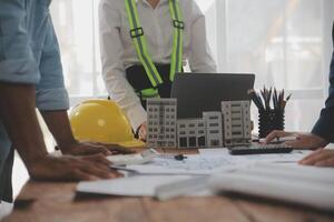 concepto de construcción y estructura de reunión de ingenieros o arquitectos para el proyecto que trabaja con socios y herramientas de ingeniería en la construcción de modelos y planos en el lugar de trabajo, contrato para ambas empresas. foto