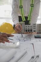 concepto de construcción y estructura de reunión de ingenieros o arquitectos para el proyecto que trabaja con socios y herramientas de ingeniería en la construcción de modelos y planos en el lugar de trabajo, contrato para ambas empresas. foto