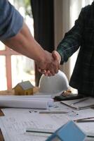 Engineer and contractor join hands after signing contract,They are having a modern building project together. successful cooperation team concept photo