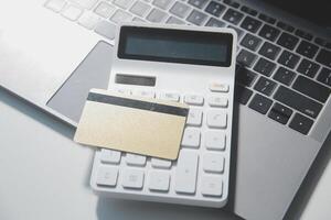 Calculator on a dark background, plastic cards and banknotes photo