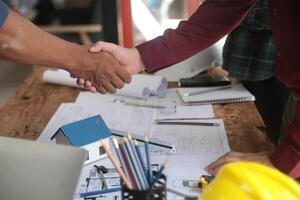 Engineer and contractor join hands after signing contract,They are having a modern building project together. successful cooperation team concept photo