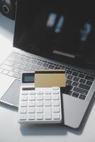 Calculator on a dark background, plastic cards and banknotes photo