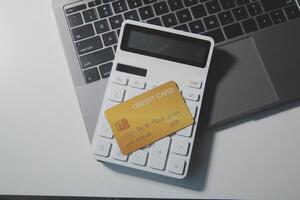 Calculator on a dark background, plastic cards and banknotes photo