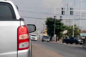 Pickup car silver color on the road stop and turn on brake light. Traffic light on the road. Blur image of traffic jam. photo