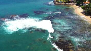 antenne visie van strand met koraal rotsen en oceaan met golven video