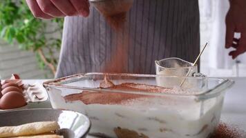homme portant tablier cuisine tiramisu à cuisine. tiramisu cuisine processus, poudrage dessert avec cacao poudre video