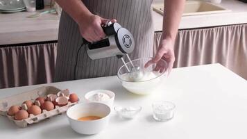 man using electric mixer whipping eggs for cream video