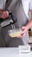 man using electric mixer whipping eggs for cream video