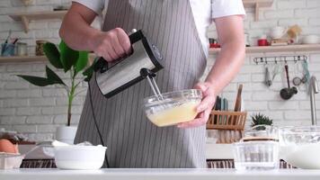 man using electric mixer whipping eggs for cream video