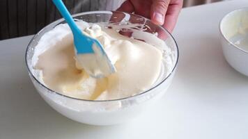 homem vestindo avental cozinhando Tiramisu às cozinha. Tiramisu cozinhando processo, mistura mascarpone e açoitado ovos creme dentro tigela, lento movimento video