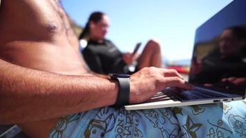 homem computador portátil mar. trabalhando remotamente em Beira Mar. feliz bem sucedido homem, masculino trabalhador autonomo trabalhando em computador portátil em praia, alivia estresse a partir de trabalhos para restaurar vida equilíbrio. freelance, controlo remoto trabalhos em período de férias video