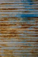 Vertical blue gray corrugated steel fence or wall surface with orange rust marks photo