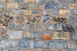 Rough ancient stone masonry wall texture background photo