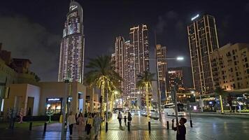 Dubai - - vereinigt arabisch Emirate 01.05.2024 beschwingt Nachtleben auf ein geschäftig Dubai Straße, Nacht Szene auf ein geschäftig Straße im Dubai, gefüttert mit Wolkenkratzer und beschwingt mit Fußgänger genießen das städtisch video