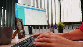 mujer dedos trabajando en un computadora teclado en moderno oficina habitación video