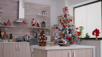 tömma xmas dekorerad kök med ingen i den är redo för jul morgon- efterrätt. på tabell bakad kaka efterrätt med kopp av kaffe väntar för gäst under vinter- högtider video