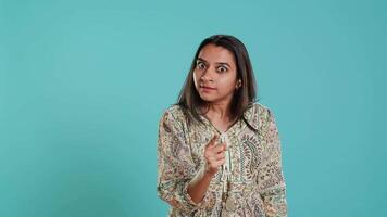 Upset indian person fighting with friend, doing scolding gesturing, isolated over studio backdrop. Annoyed woman arguing with opponent during discussion, doing admonishing hand gestures, camera A video