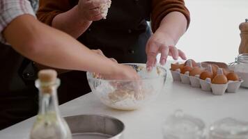 Nahansicht von Enkelin Hände vorbereiten hausgemacht traditionell Kekse Teig mit Mehl während Weihnachtszeit im Weihnachten dekoriert Küche. Familie feiern Weihnachten Herstellung Winter Dessert video