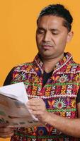 Vertical Irked manager looking over company financial profit report audit, disappointed by results, isolated over studio background. Mad indian man throwing business documents in frustration, camera A video