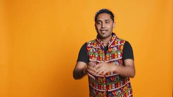 Smiling person having fun, dancing on rhythm, enjoying relaxation time. Jolly indian man goofing around, entertaining himself doing funky movements, isolated over studio background, camera B video