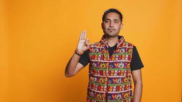 Indian man doing ok hand sign, feeling pleased, agreeing with satisfactory conclusion. Optimistic person doing okay symbol gesturing, offering positive feedback, studio background, camera B video